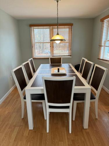 a dining room with a white table and chairs at Charming Lake Community Bungalow in Barnstead