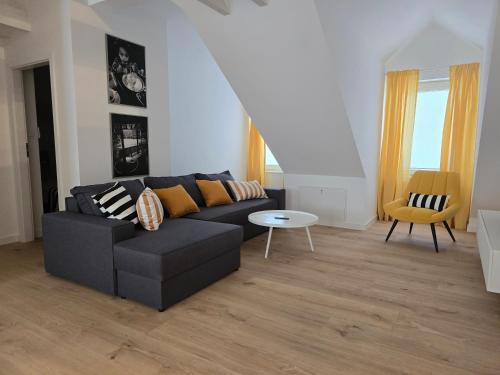 a living room with a black couch and a table at Apartments Orkana Street in Oborniki Śląskie