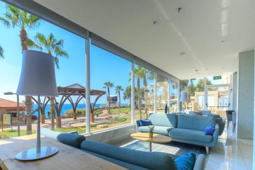 a living room with palm trees and a blue couch at Residence Hotel in Netanya