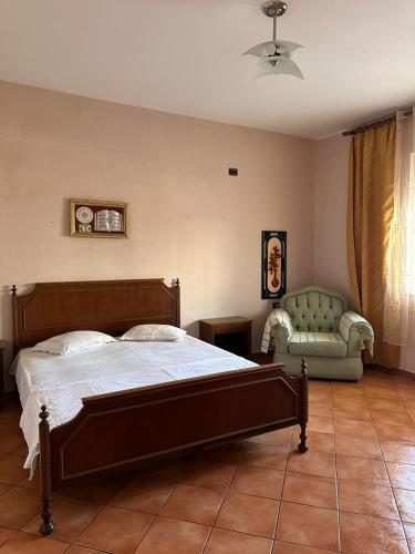 a bedroom with a bed and a couch and a chair at Villa Abba in Durrës