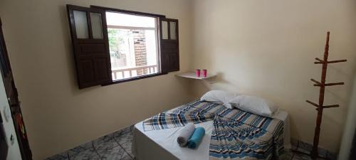 Ένα ή περισσότερα κρεβάτια σε δωμάτιο στο Arraial Hospedagens