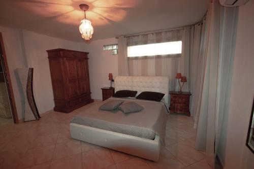 a bedroom with a large bed and a window at Villa Gallo - Seminterrato luminoso in Capoterra