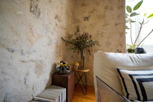 un salon avec une chaise et un vase de fleurs dans l'établissement Chic Apartment with Private Terrace, à Paris