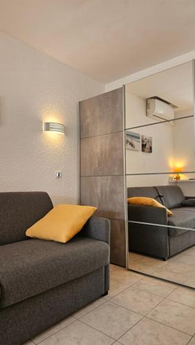 a living room with a couch and a bed at Grand studio rénové avec terrasse et clim ! in Cap d'Agde