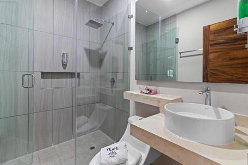 a bathroom with a shower and a toilet and a sink at Hotel Yeah Rinc&oacute;n de Guayabitos in Rincon de Guayabitos