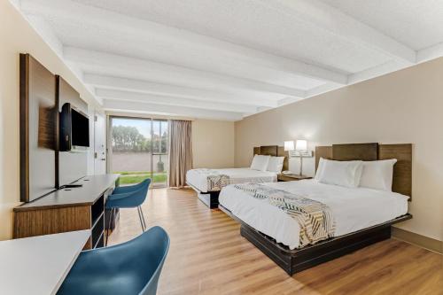 a hotel room with two beds and a desk at Red Carpet Inn & Suites in Philadelphia