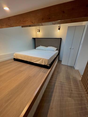 une chambre avec un grand lit et un parquet dans l'établissement Magnifique Studio duplex,150 mt de la plage et centre ville,clime,wifi, à Bormes-les-Mimosas