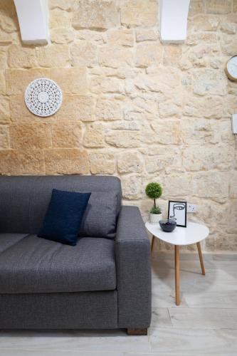 a living room with a couch and a table at Blue Hues Katerina - House of Character in Qormi