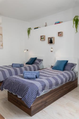 two beds in a white room with blue pillows on them at Blue Hues Katerina - House of Character in Qormi