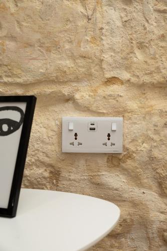 a white electrical outlet on a stone wall at Blue Hues Katerina - House of Character in Qormi