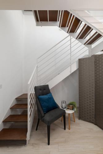 a chair in a room with a staircase at Blue Hues Katerina - House of Character in Qormi