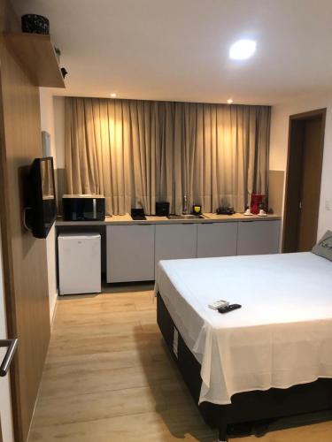a hotel room with a bed and a kitchen at Flat Maravilhoso na Praia de Cabo Branco in João Pessoa