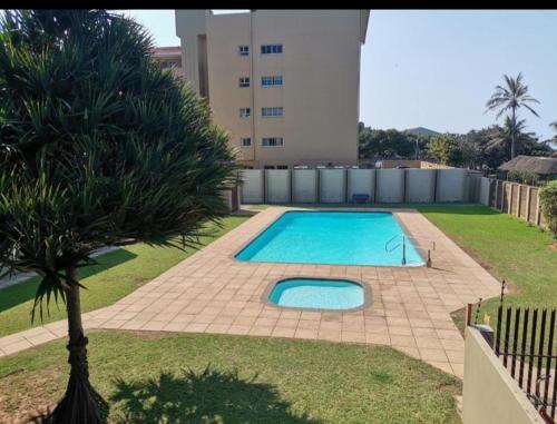 a swimming pool in front of a building at 88 on Stella Maris in Amanzimtoti