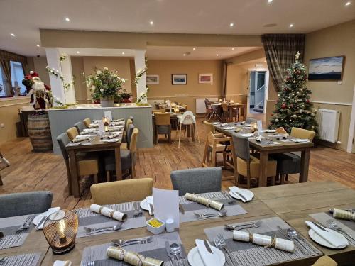 a dining room with tables and a christmas tree at Northern Sands Hotel in Dunnet