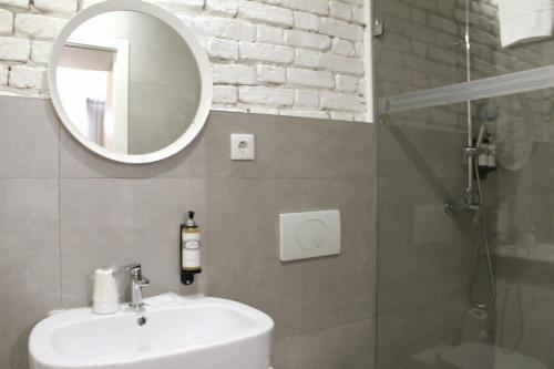 a bathroom with a sink and a mirror and a shower at Bemyguest - Loft Guest House Jardim das Mães Charming in Viseu