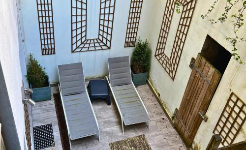 deux chaises assises à côté d'un bâtiment avec des fenêtres dans l'établissement La Sirena - Appartements Face Mer et Nausicaa, à Boulogne-sur-Mer