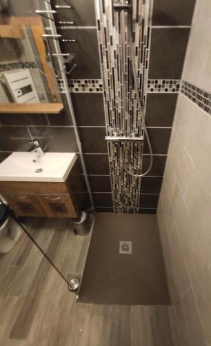 une salle de bain avec un lavabo et un miroir dans l'établissement Bel appartement avec piscine, terrasse avec vue sur les montagnes, à Hendaye