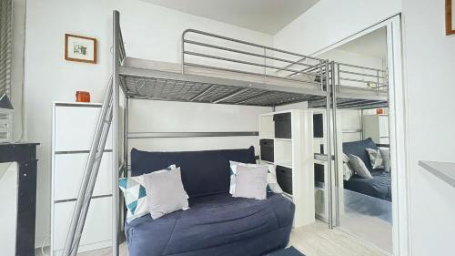 - une chambre avec des lits superposés et un canapé bleu dans l'établissement Studio proche Paris, à Maisons-Alfort