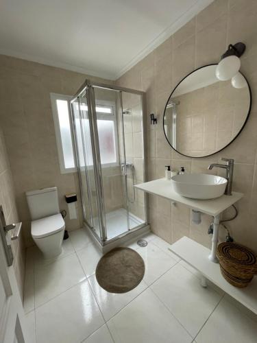 a bathroom with a sink toilet and a mirror at Casa con terraza en La Plazuela in Arrecife