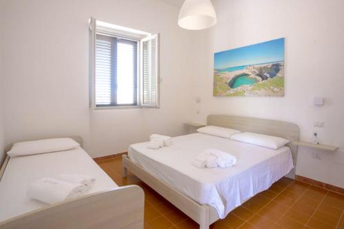 a bedroom with two beds and a window at Casa Vacanze Vento del Sud in Porto Cesareo