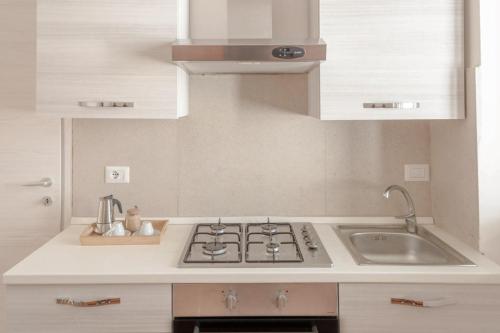 a kitchen with a stove and a sink at Casa Vacanze Vento del Sud in Porto Cesareo