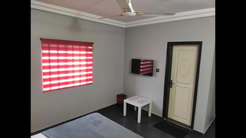 a white room with a door and a window at Deluxe Double Bed in Royal Blue Guest House and Bar 02 in Lomé