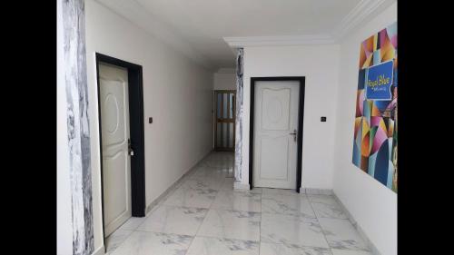 an empty hallway with two doors and a tile floor at Deluxe Double Bed in Royal Blue Guest House and Bar 02 in Lomé