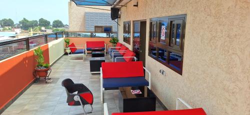 a balcony with red chairs and tables on a building at Deluxe Double Bed in Royal Blue Guest House and Bar 02 in Lomé