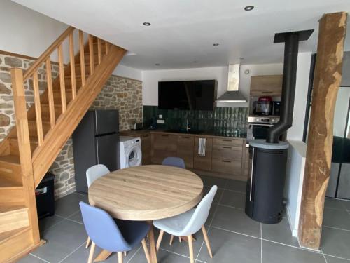 une cuisine et une salle à manger avec une table et des chaises en bois dans l'établissement La ville es goutté, à Créhen