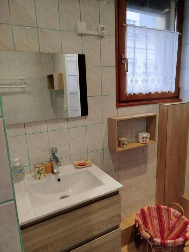 une salle de bain avec un lavabo et un miroir dans l'établissement la villa des bon enfants, au Tréport