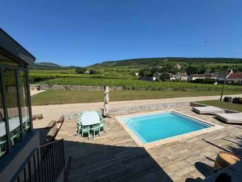 une piscine avec une table et une chaise dans l'établissement Le Clos de la Chapelle, à Santenay