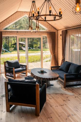 a living room with a couch and a table at Paežerės istorijos, Druskininkai in Veršiai