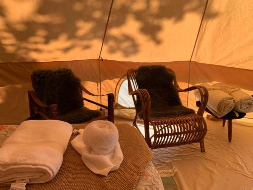 a room with two chairs and a baby in a tent at Glamping with outdoor wood-fired hot tub in Vissenbjerg