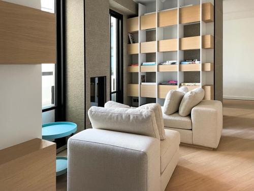 a living room with two white chairs and a table at Cité Privée - FORBIDDEN CITY Hotels in Kalkara
