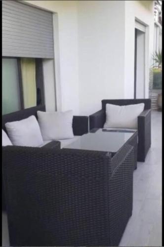 two wicker chairs and a table on a patio at Appartement résidence -Sidi Rahal in Sidi Rahal