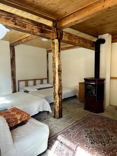 a room with two beds and a wood stove at vallemaira house "Chalet Le Terrazze" 2-12 Persone in exclusiva da 2 persone in San Damiano Macra
