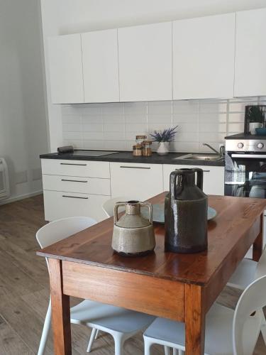 a kitchen with a wooden table with two bells on it at Domu Oltremare in Selargius