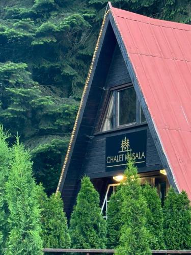 a log cabin with a red roof and trees at Chalet Musala Borovets by BookVillaBG in Borovets