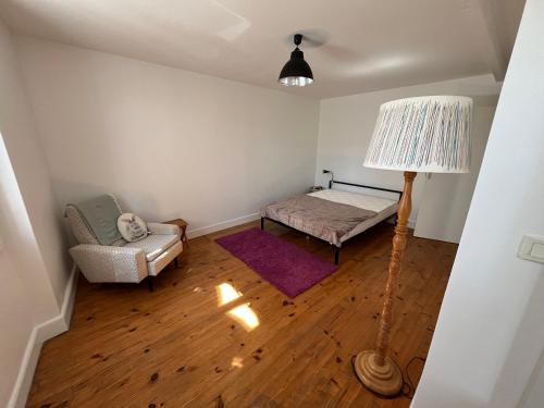 a bedroom with a bed and a lamp and a chair at Le gîte des Archers in Rieux