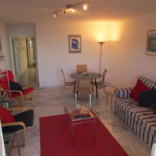 un salon avec un canapé, une table et des chaises dans l'établissement Deux pièces rare avec vue, à Roquebrune-Cap-Martin