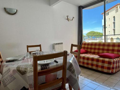 - une salle à manger avec une table, un canapé et une fenêtre dans l'établissement Appartement 2 pièces cabine - 66700 Argelès sur mer AR260-101, à Argelès-sur-Mer