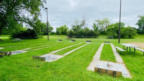 a park with picnic tables and benches in the grass at Kash Park Play & Stay in Stevens Point