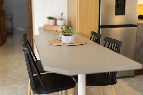 a white table with chairs and a white refrigerator at Villa Aelia Luxury Maisonette in Salamís