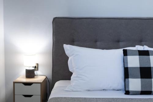 a bed with a black and white pillow and a night stand at Villa Aelia Luxury Maisonette in Salamís