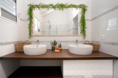 two sinks in a bathroom with a mirror at Studio avec piscine in Cul de Sac