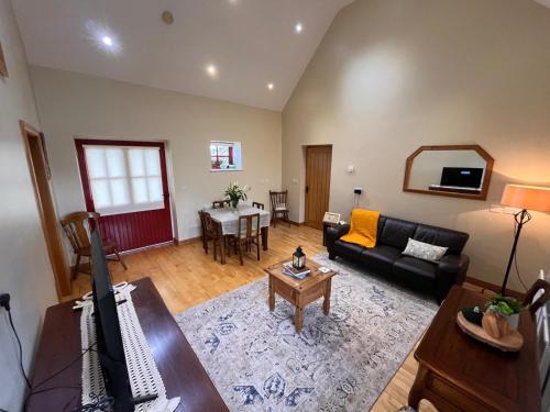 a living room with a couch and a table at Minnie’s Cottage in Killylea