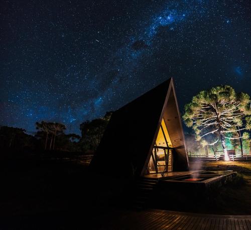 a cabin under a starry sky at night at Chalé Com Banheira e Piscina - Urubici- SC in Urubici