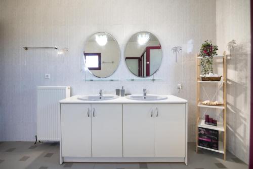 a white bathroom with two sinks and a mirror at Villa Aelia Luxury Maisonette in Salamís