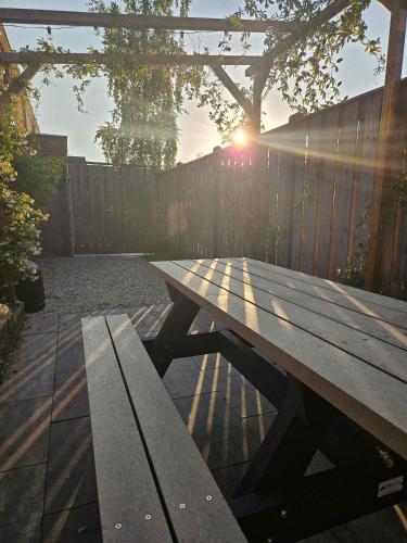 a wooden picnic table in front of a fence at Eco lodge Utrecht Leidsche Rijn in Utrecht