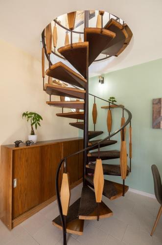a spiral staircase in a living room with a wooden wall at Villa Aelia Luxury Maisonette in Salamís
